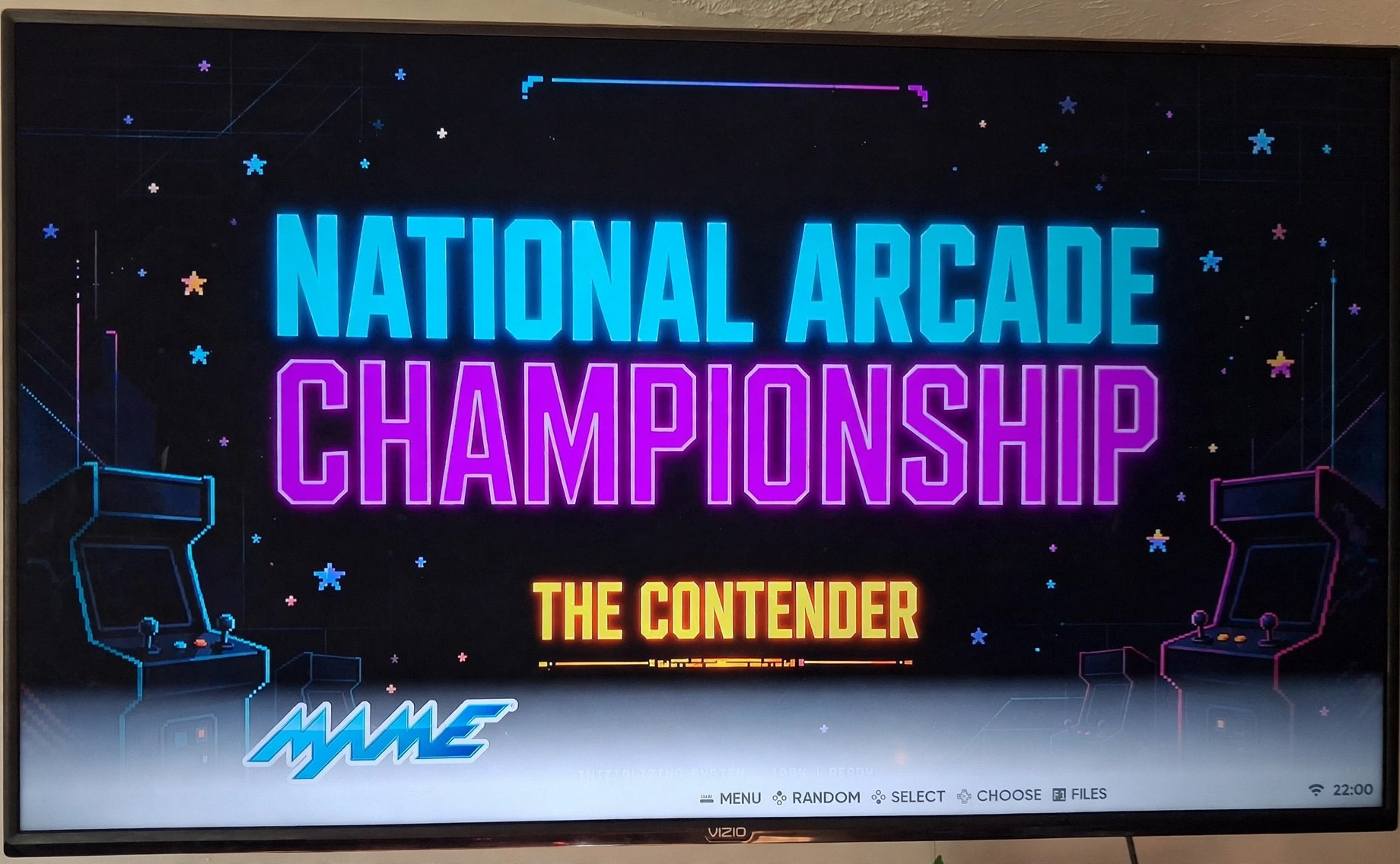 A big TV showing the National Arcade Championship logo screen at a party setup